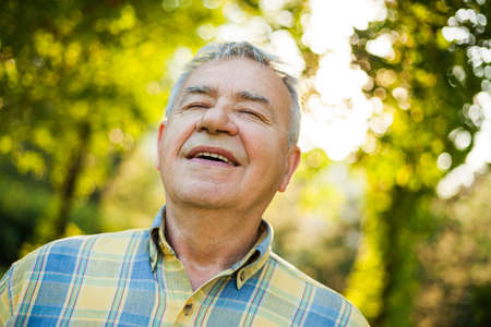 Happy senior man is enjoying fresh air in nature.の写真素材