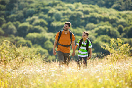 Father and son are hiking in nature in summer.の写真素材
