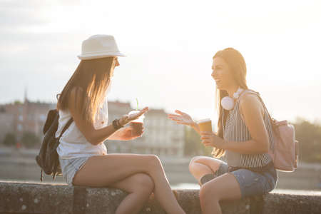 Two happy women are having fun together in the city in summer.の写真素材