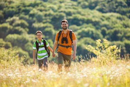 Father and son are hiking in nature in summer.の写真素材