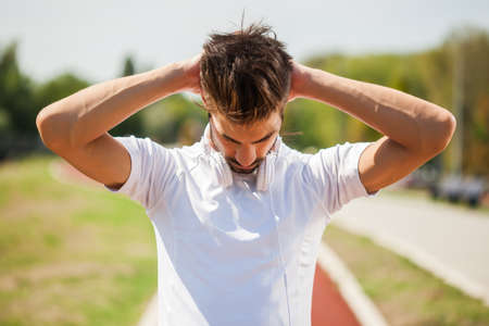 Young man is exercising on sunny day. He is stretching his body.の写真素材