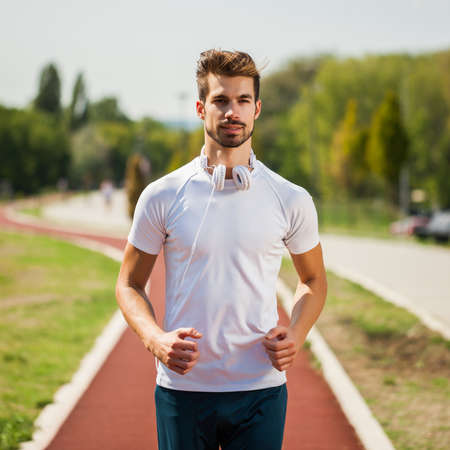 Young man is jogging on sunny day.の写真素材