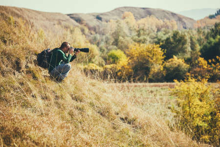 Photographer taking photos in mountain in autumn.の写真素材