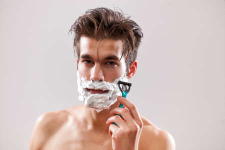 Young handsome man is shaving his beard.の写真素材