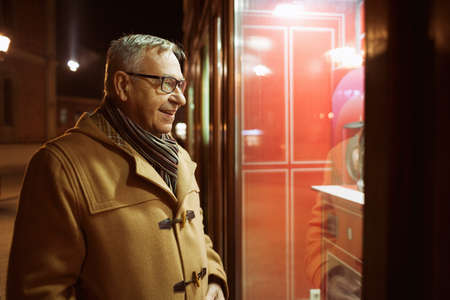 Senior man is shopping and looking at store front.の写真素材