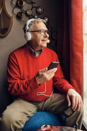 Senior man is sitting in cafe and chatting.の写真素材