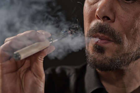 Close up image of man who is smoking electronic cigarette.の写真素材