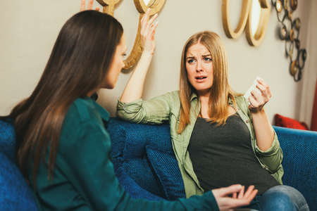 Young woman is sad, she is talking to a friend in cafe.の写真素材