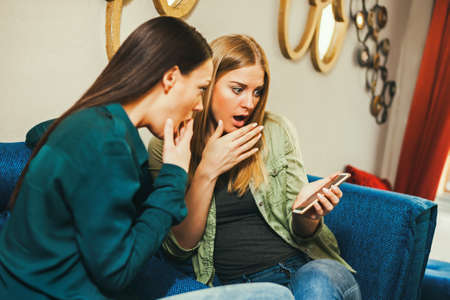 Two women are sitting in cafe and talking.の写真素材