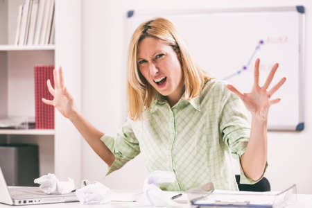 Businesswoman is angry because she is tired of overtime work.の写真素材