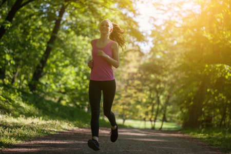 Young woman is jogging in park.