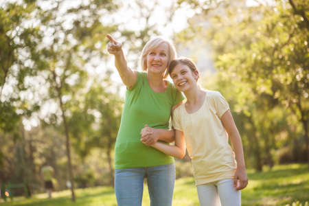 Grandmother and granddaughter are having fun together in park.の写真素材
