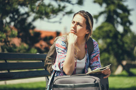 Young woman is going on vacation. She is waiting for her transportation.の写真素材