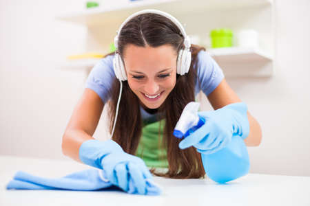 Young happy woman is cleaning the kitchen.の写真素材