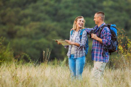 Happy couple is hiking in mountain.の写真素材