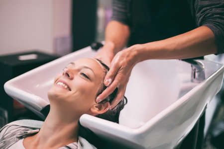 Young woman getting new hairstyle at professional hair styling saloon.の写真素材