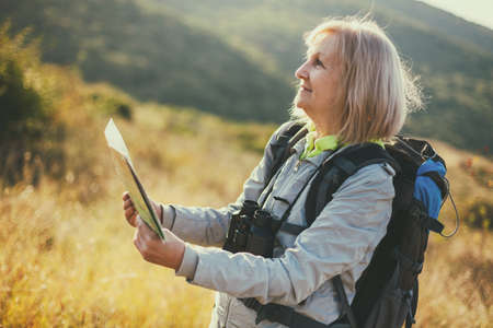 Senior woman is hiking in mountain. Active retirement.