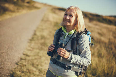 Senior woman is hiking in mountain. Active retirement.の写真素材