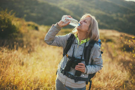 Senior woman is hiking in mountain. Active retirement.の写真素材