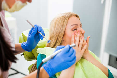 Young woman at dentist. She is afraid.の写真素材
