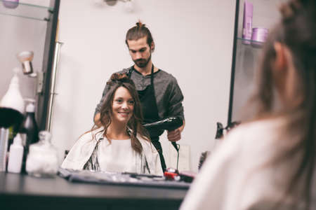 Young woman getting new hairstyle at professional hair styling saloon.の写真素材