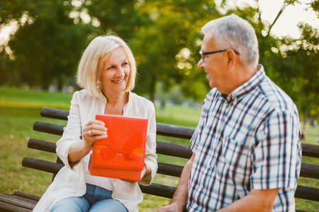 Senior woman is delighted with gift from her man.の写真素材