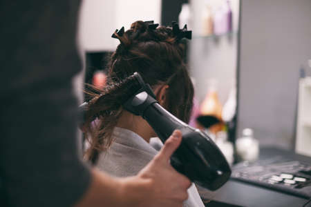 Young woman getting new hairstyle at professional hair styling saloon.の写真素材