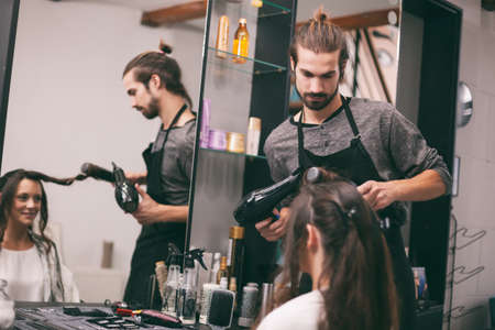 Young woman getting new hairstyle at professional hair styling saloon.の写真素材