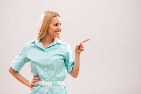 Portrait of young nurse who is pointing at advert.の写真素材