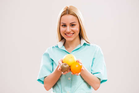 Portrait of young nurse who is holding fruit.の写真素材