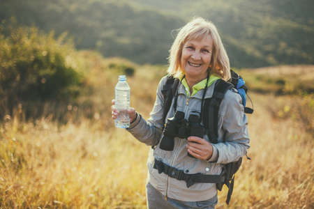 Senior woman is hiking in mountain. Active retirement.の写真素材