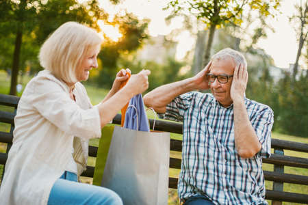 Senior man is angry because his woman is spending money on clothes.の写真素材