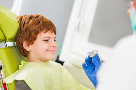 Dentist is teaching little boy about braces.の写真素材