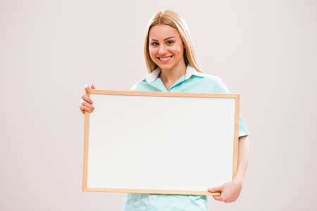 Portrait of young nurse who is holding whiteboard.の写真素材