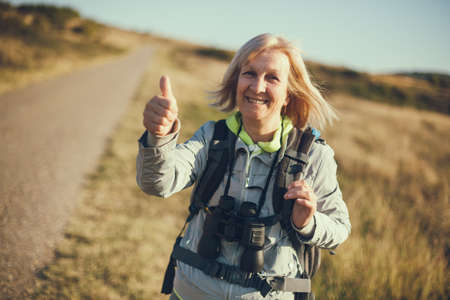 Senior woman is hiking in mountain. Active retirement.の写真素材