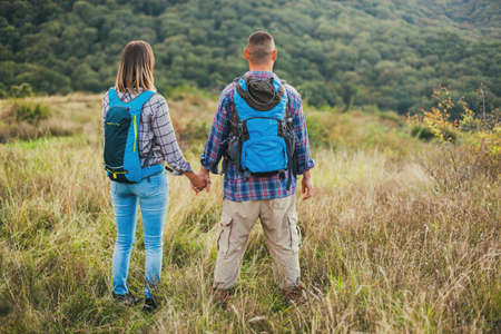 Happy couple is hiking in mountain.の写真素材