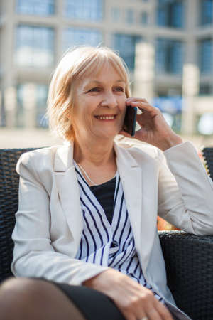 Senior businesswoman having coffee break in cafeの写真素材