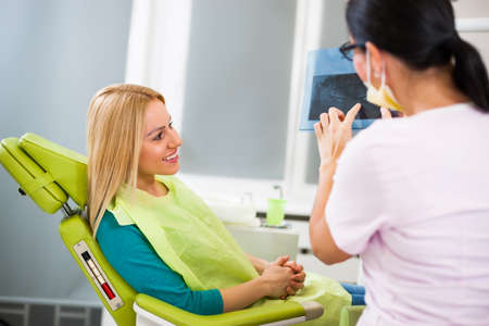 Young woman at dentist. Examining x-ray image.の写真素材