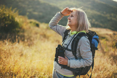 Senior woman is hiking in mountain. Active retirement.の写真素材