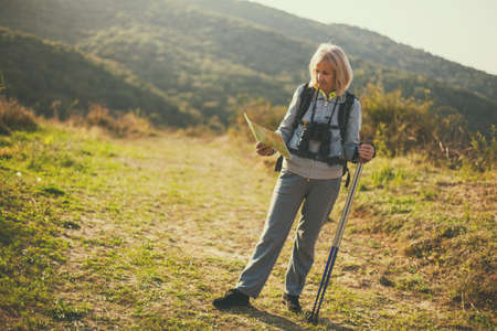 Senior woman is hiking in mountain. Active retirement.の写真素材