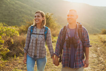 Happy couple is hiking in mountain.の写真素材