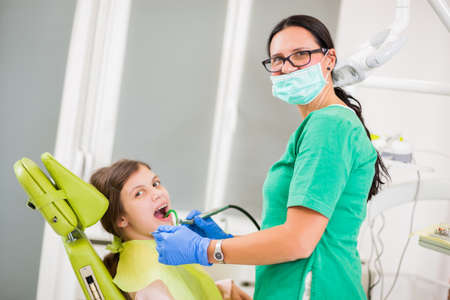 Dentist is repairing teeth of little girl.の写真素材
