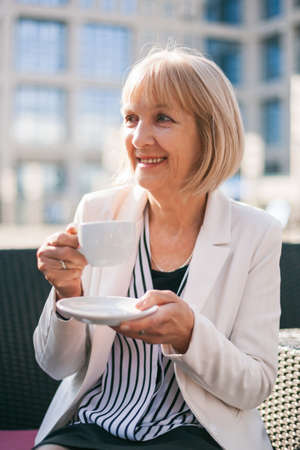 Senior businesswoman having coffee break in cafeの写真素材