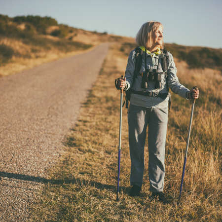 Senior woman is hiking in mountain. Active retirement.の写真素材