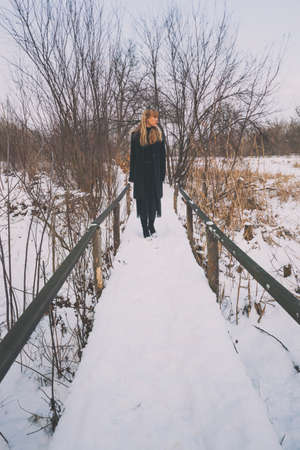 Lonely woman walking in park in winter.の写真素材