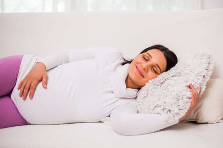 Happy pregnant woman relaxing at home.の写真素材