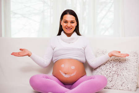 Happy pregnant woman relaxing at home.の写真素材
