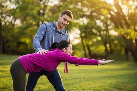 Physical therapist is showing exercises for sciatica recovery to young patient.の写真素材