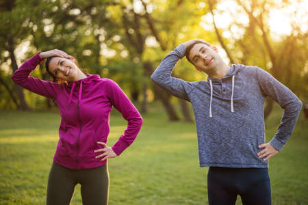Happy couple is exercising in park.の写真素材