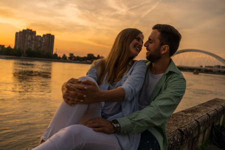 Happy couple in love embracing at river bank in the city.の写真素材